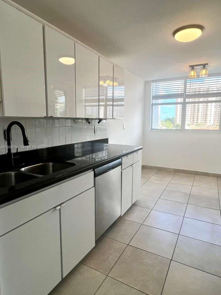 100 Golden Isles Drive, Unit 406 Hallandale Beach, FL 33009 - Photo 5 of 31 a kitchen with a sink and cabinets