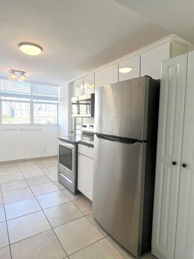 100 Golden Isles Drive, Unit 406 Hallandale Beach, FL 33009 - Photo 6 of 31 a kitchen with granite countertop a refrigerator and a sink