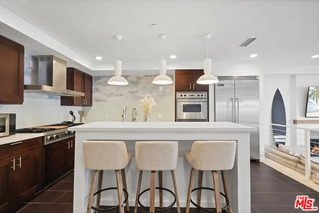 a kitchen with stainless steel appliances granite countertop a table chairs sink and cabinets