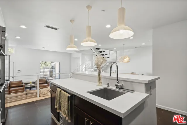 a kitchen with a sink a stove and chairs