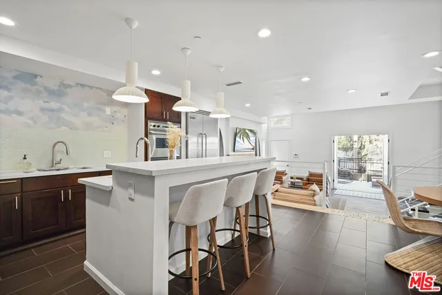 a kitchen with stainless steel appliances kitchen island granite countertop a table and chairs in it