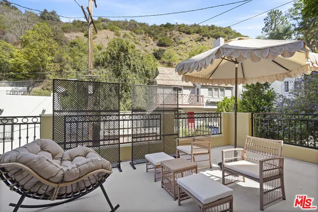 a view of a patio with couches chairs under an umbrella