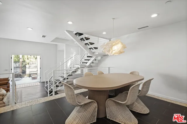 a dining room with furniture a chandelier and wooden floor
