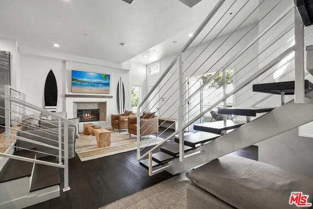 a living room with fireplace furniture and a potted plant