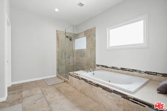 a spacious bathroom with a bathtub and shower
