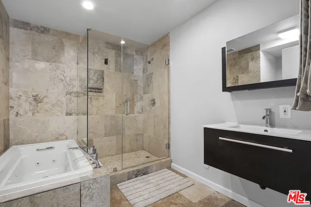 a bathroom with a tub a sink and mirror