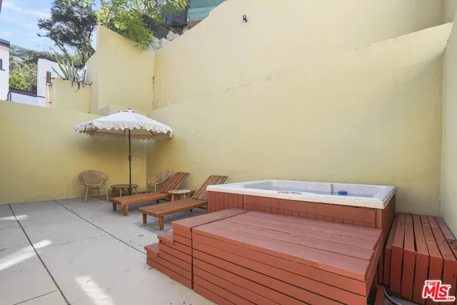 a view of a patio with a table and chairs under an umbrella