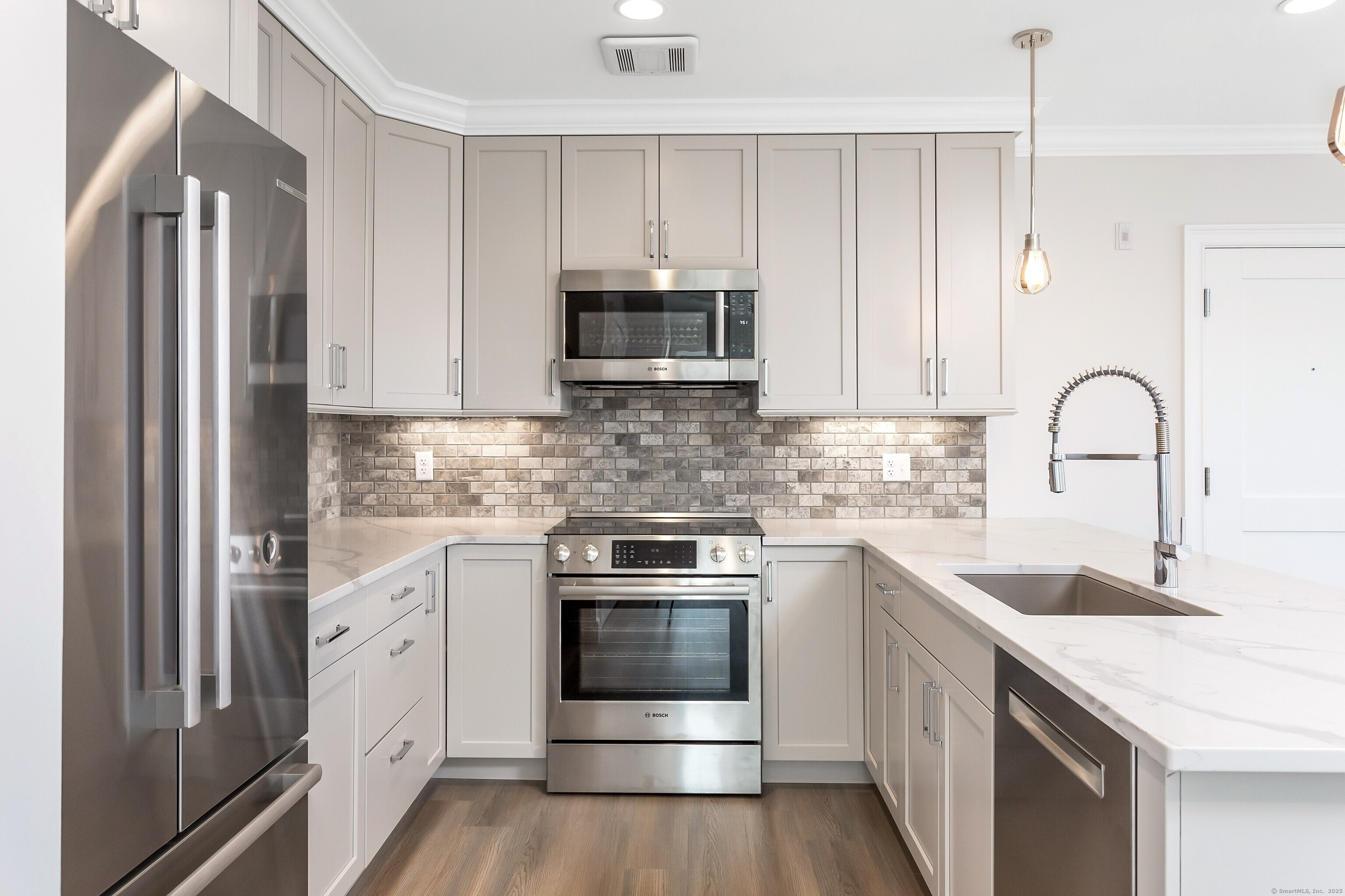 a kitchen with stainless steel appliances granite countertop a stove a sink and a refrigerator