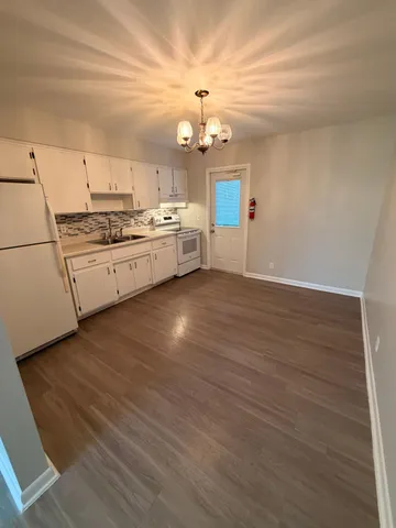 a kitchen with a sink cabinets and wooden floor