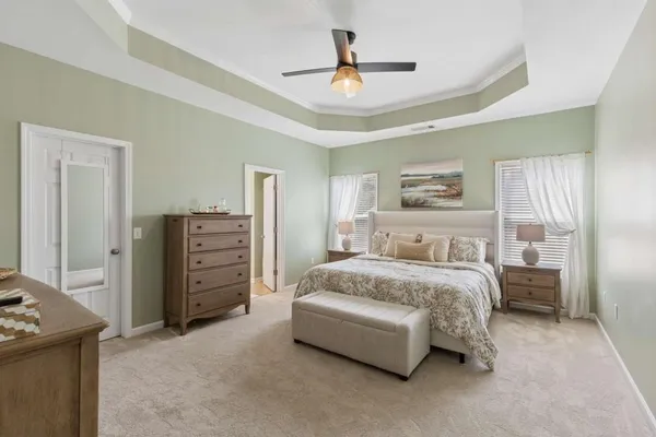 a spacious bedroom with a bed and a chandelier