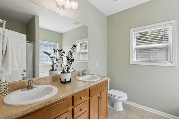 a bathroom with a granite countertop sink toilet and mirror