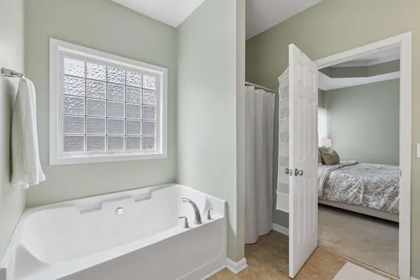a en suite bathroom with a tub shower and window