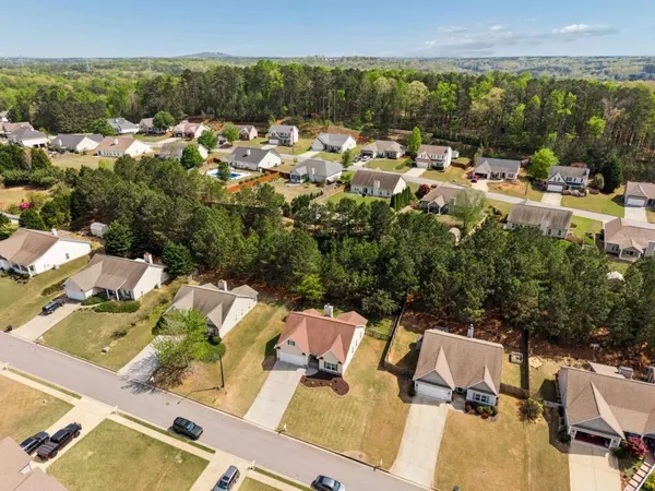 aerial view of a house with a yard and lake view