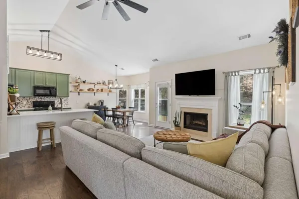 a living room with furniture a fireplace and a flat screen tv