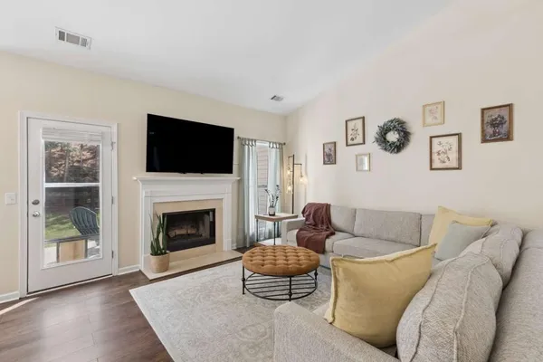 a living room with furniture a flat screen tv and a fireplace