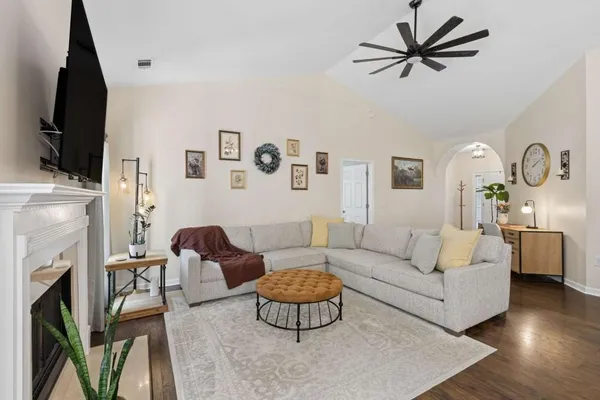 a living room with furniture a fireplace and a flat screen tv
