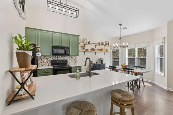 a dining room with furniture a chandelier and wooden floor