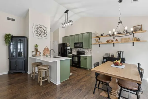 a view of a dining room and livingroom with furniture wooden floor a chandelier