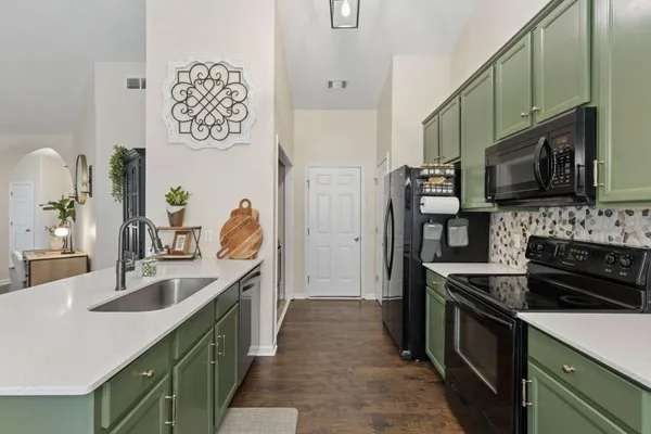 a kitchen with kitchen island granite countertop a sink stove and refrigerator