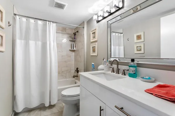 a bedroom with a bed and a flat tv screen on the dresser
