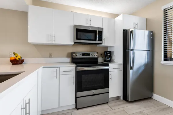 a kitchen with white cabinets and sink