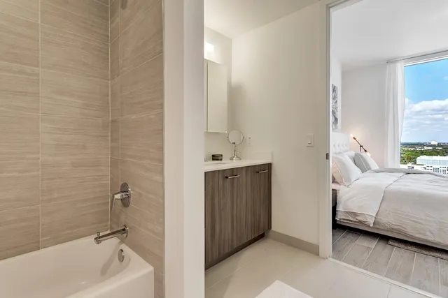 a bathroom with a tub a sink and a mirror