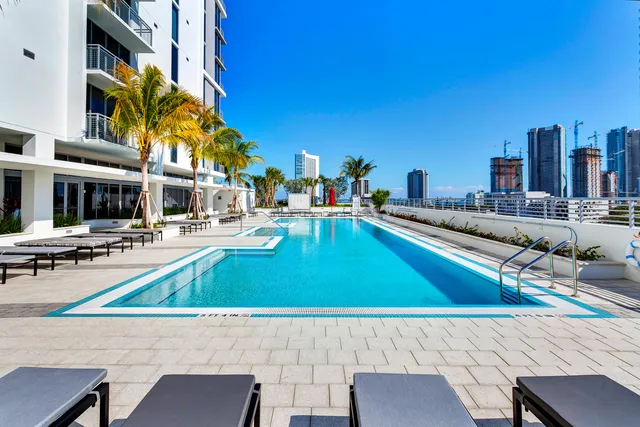 a swimming pool with outdoor seating and city view