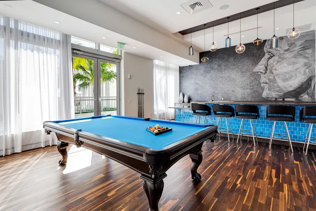 a room with furniture pool table wooden floor and windows