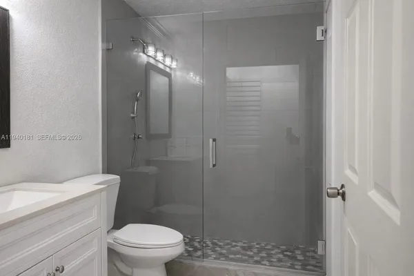 a bathroom with a toilet a sink and shower