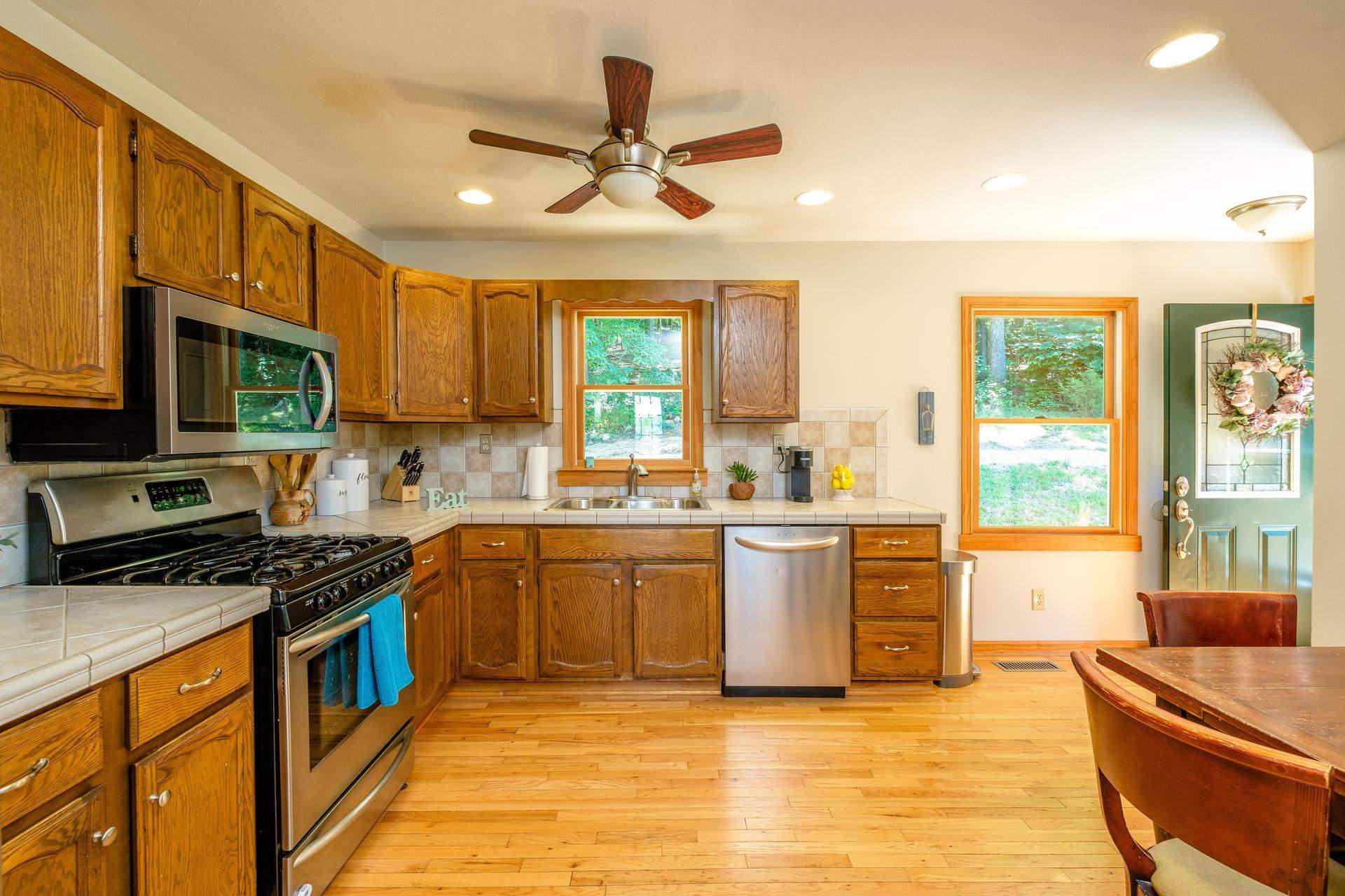 577 Union Church Road Churchville, VA 24421 - Photo 6 of 35 a kitchen with stainless steel appliances granite countertop a stove top oven a sink dishwasher a dining table and chairs with wooden floor