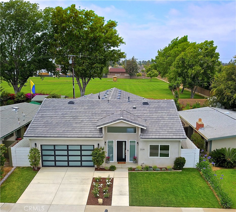 2339 Westminster Avenue Costa Mesa, CA 92627 - Photo 31 of 36 a view of a white house with a yard potted plants and a large tree