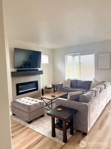 a living room with furniture a fireplace and a flat screen tv