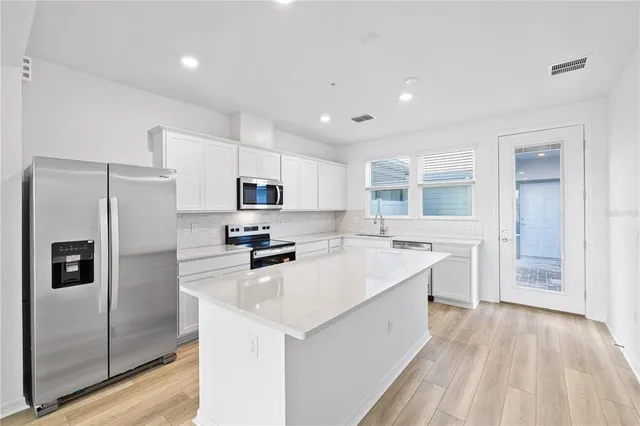 a kitchen with stainless steel appliances a refrigerator stove microwave and cabinets