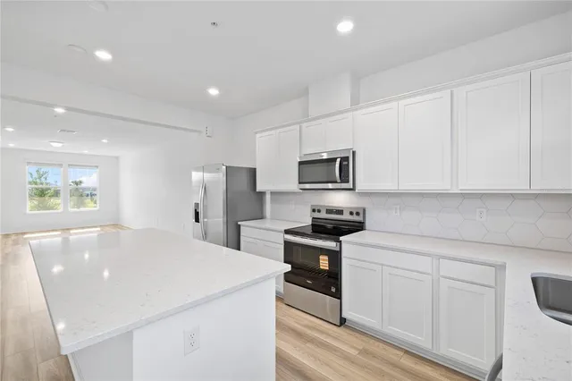 a kitchen with stainless steel appliances a refrigerator sink and microwave