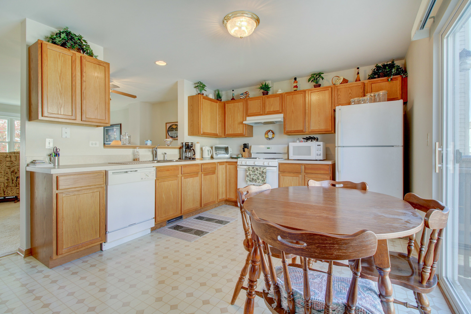 34295 North Barberry Road Round Lake, IL 60073 - Photo 13 of 23 a kitchen with a table chairs refrigerator and cabinets