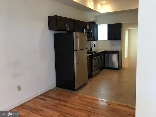 a kitchen with stainless steel appliances granite countertop a refrigerator and a stove