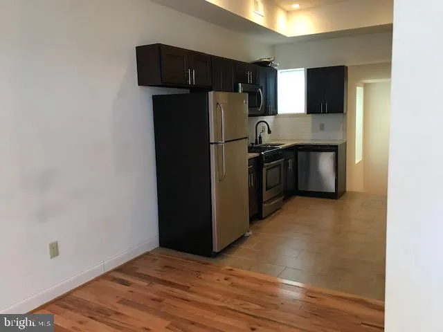 a kitchen with stainless steel appliances granite countertop a refrigerator and a stove