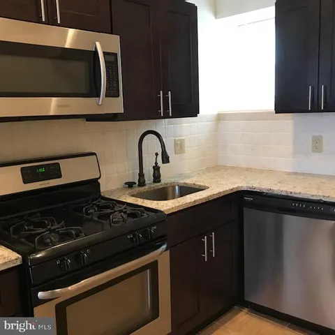 a kitchen with stainless steel appliances granite countertop a stove and a microwave