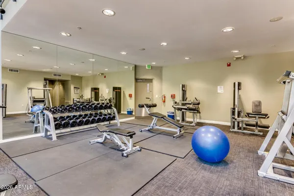 a room with gym equipment and kitchen view