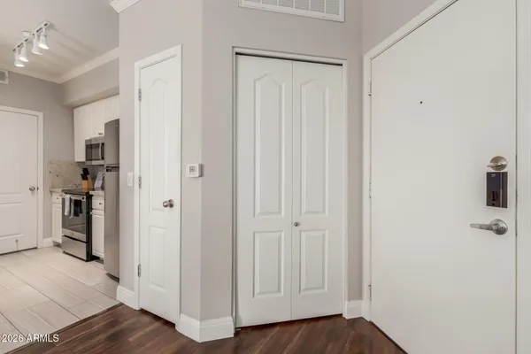 a view of a hallway with wooden floor and closet