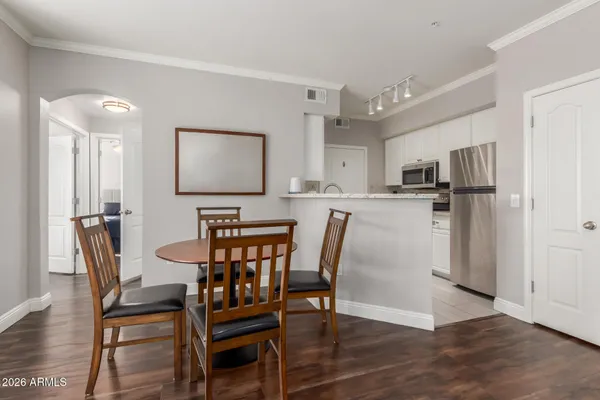 a kitchen with stainless steel appliances a dining table chairs and wooden floor