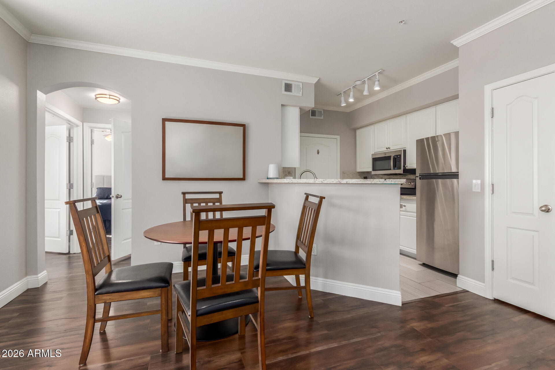 1701 East Colter Street, Unit 477 Phoenix, AZ 85016 - Photo 4 of 39 a kitchen with stainless steel appliances a dining table chairs and wooden floor