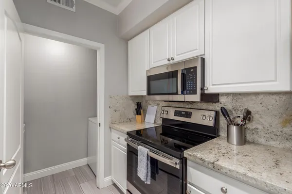 a kitchen with granite countertop a stove and a microwave