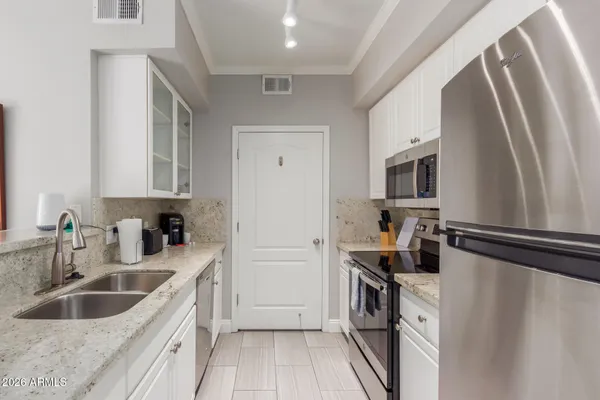 a kitchen with stainless steel appliances granite countertop a sink and a stove