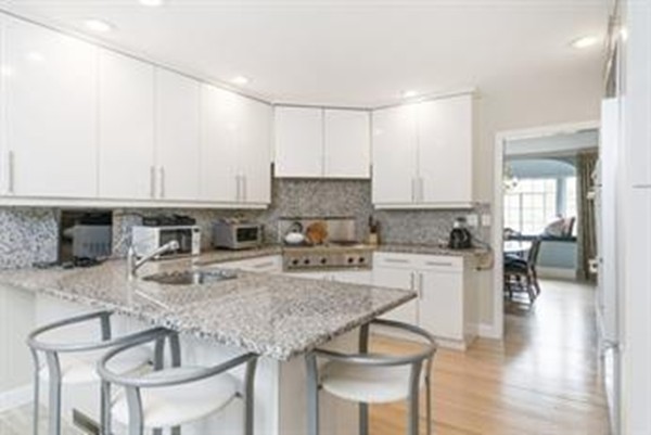 101 Stuart Road Newton, MA 02459 - Photo 10 of 26 a kitchen with stainless steel appliances granite countertop a stove top oven a sink a dining table and chairs