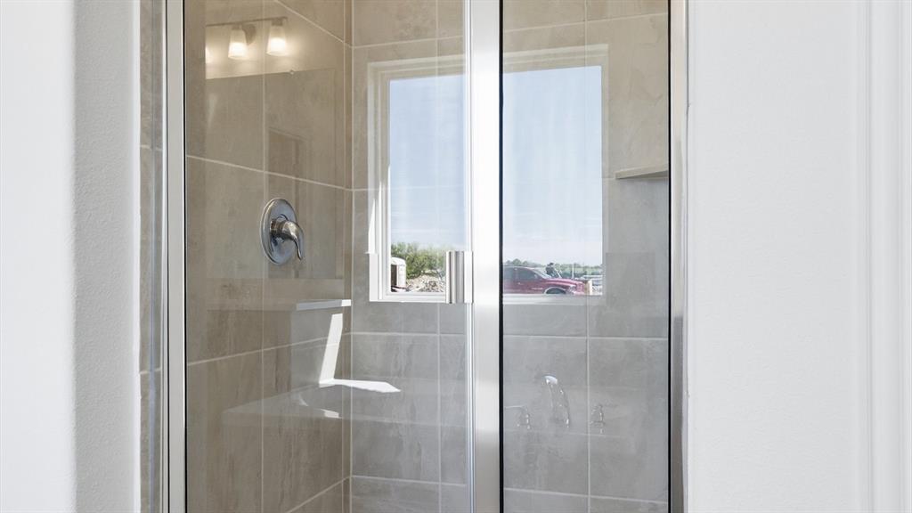 2529 Rivers W Road Anna, TX 75409 - Photo 34 of 40 Glass-enclosed shower with tile surround and integrated shelving