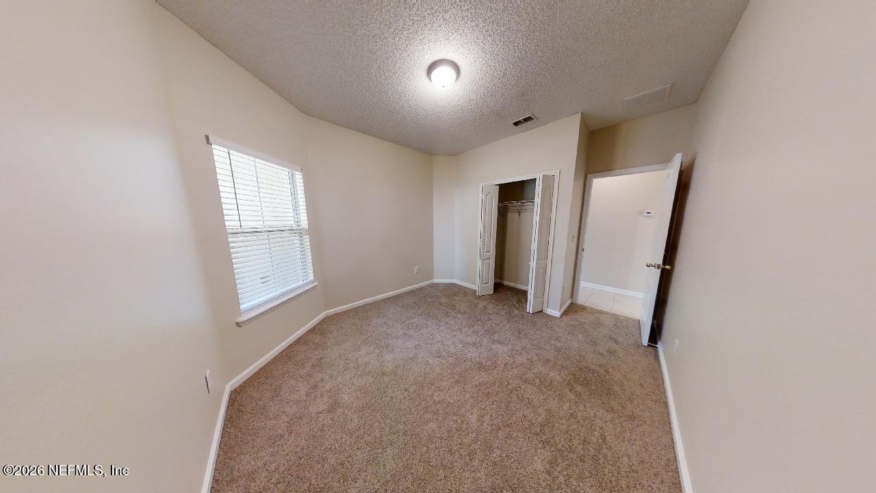 14454 Millhopper Road Jacksonville, FL 32258 - Photo 24 of 44 an empty room with windows and cabinet