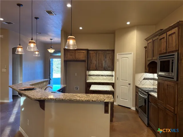 a kitchen with a sink stove and refrigerator