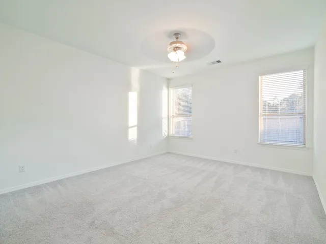 an empty room with windows and chandelier