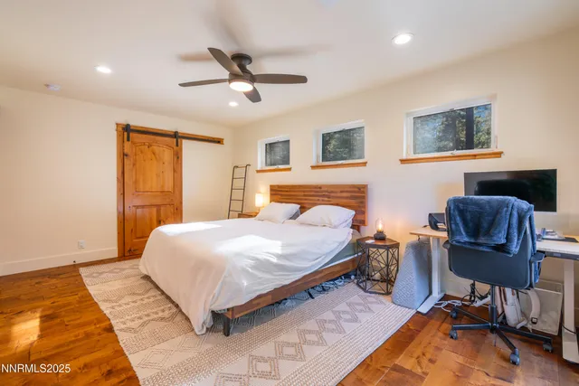 a bedroom with a bed and wooden floor